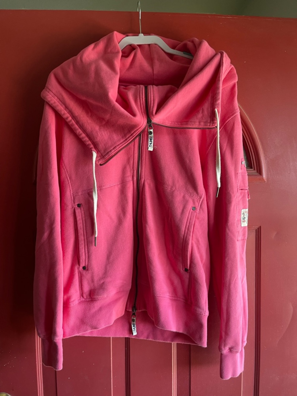 Hot pink THUMB Zip-Up Hoodie Jacket with a zip up collar cross posted